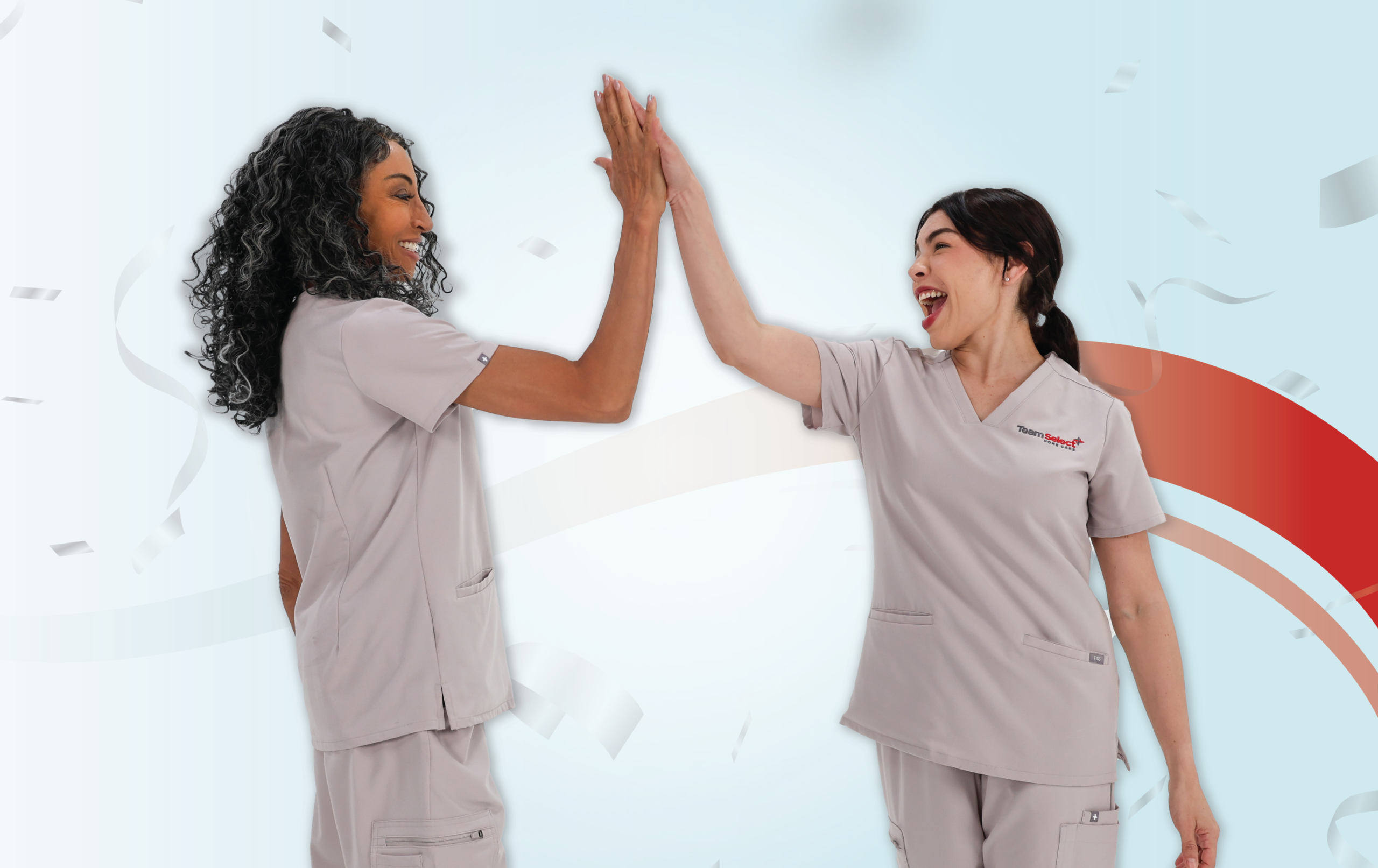 Two healthcare professionals in gray scrubs high-fiving each other with smiles against a pale blue decorative background.