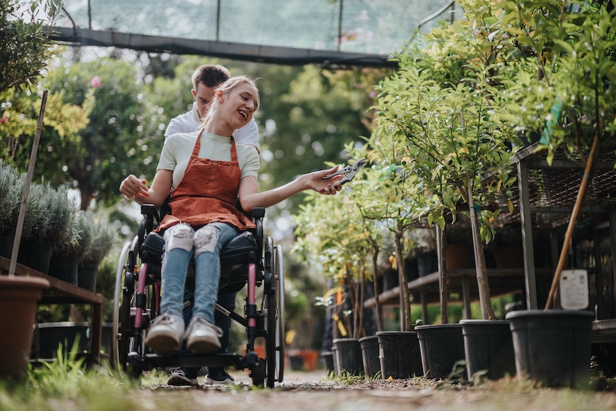 A person in a wheelchair enthusiastically tends to plants