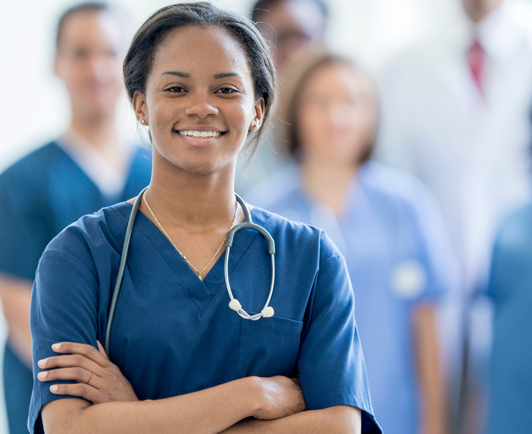 a nurse standing and smiling at the camera